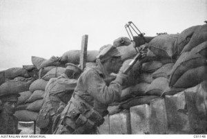 A soldier uses a periscope rifle in a trench while his mate observes for him through a periscope, Gallipoli Peninsula  1915. Image courtesy Australian War Memorial.