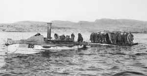 A launch tows a raft carrying artillerymen and guns out to waiting ships during the evacuation of Gallipoli Peninsula, December 1915. Image courtesy Australian War Memorial.