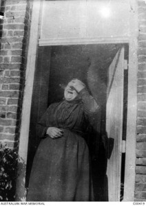Madame Bermesch laughing in the doorway of her house where members of the 1st Battalion are billeted, Nord Pas de Calais, April 1916. Image courtesy Australian War Memorial.